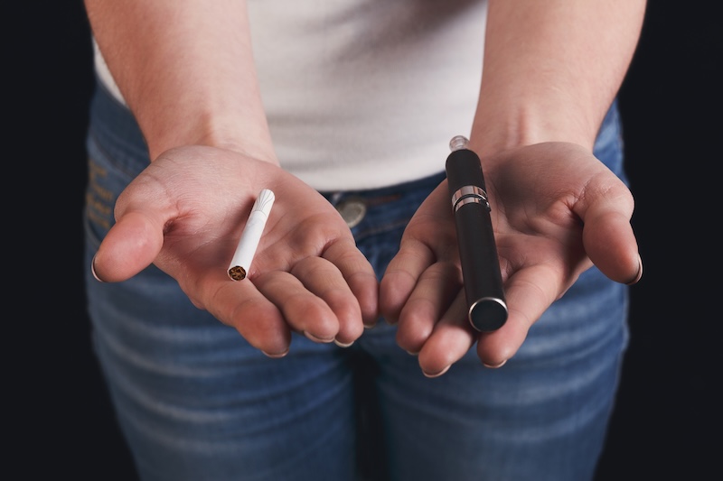 En hand med cigarett, andra hållandes vejp